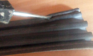 Using a flat head screwdriver to lift out the rubber holds the metal clip in place