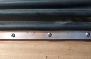 Using a Philips head screwdriver install screws to mechanically attach the boot to the flat mounting surface